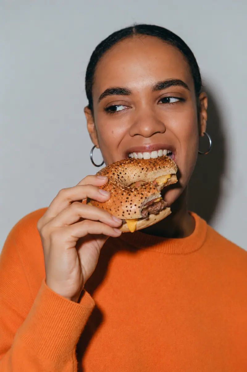 Woman biting into an everything bagel